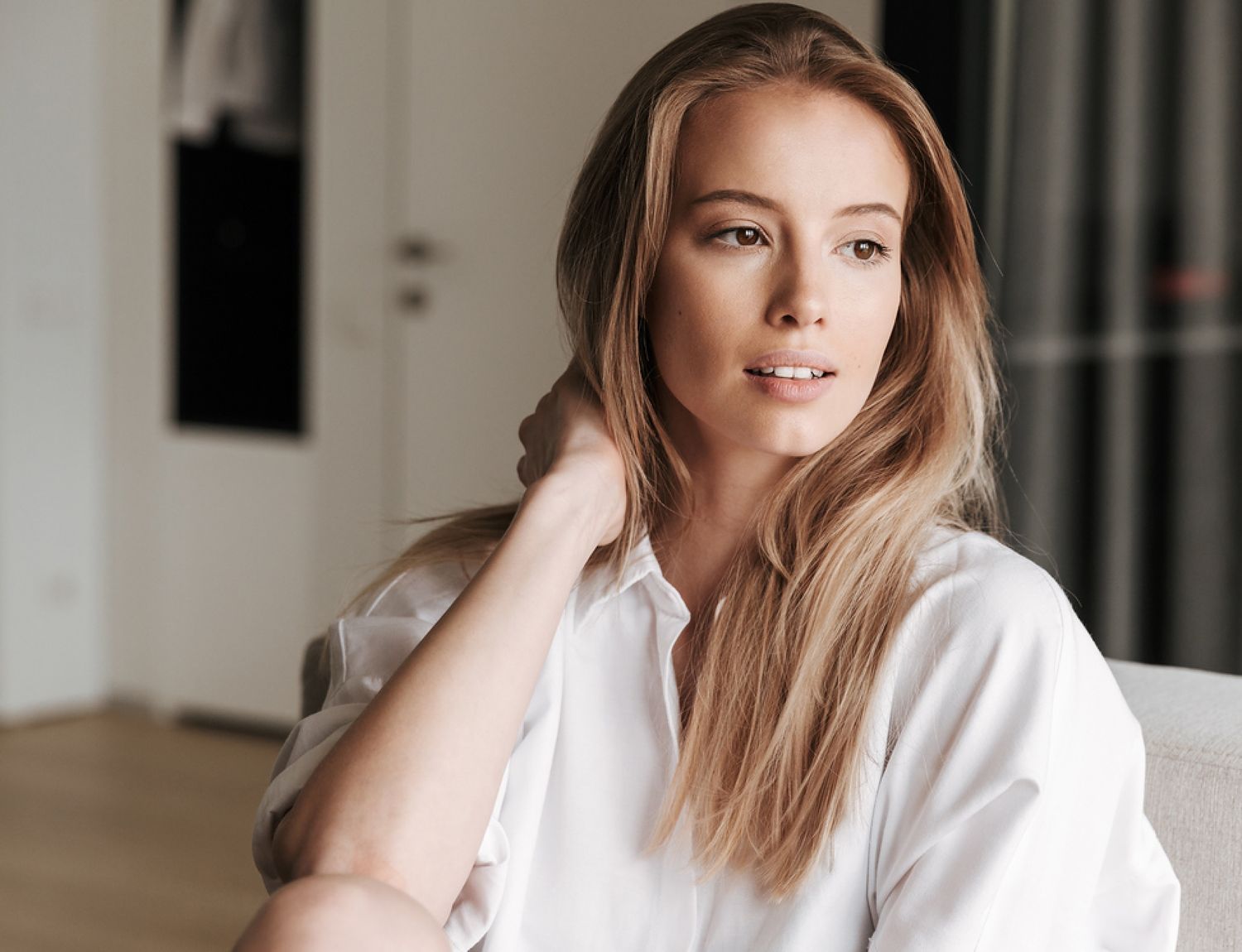 Smiling woman with clear skin against blue background.