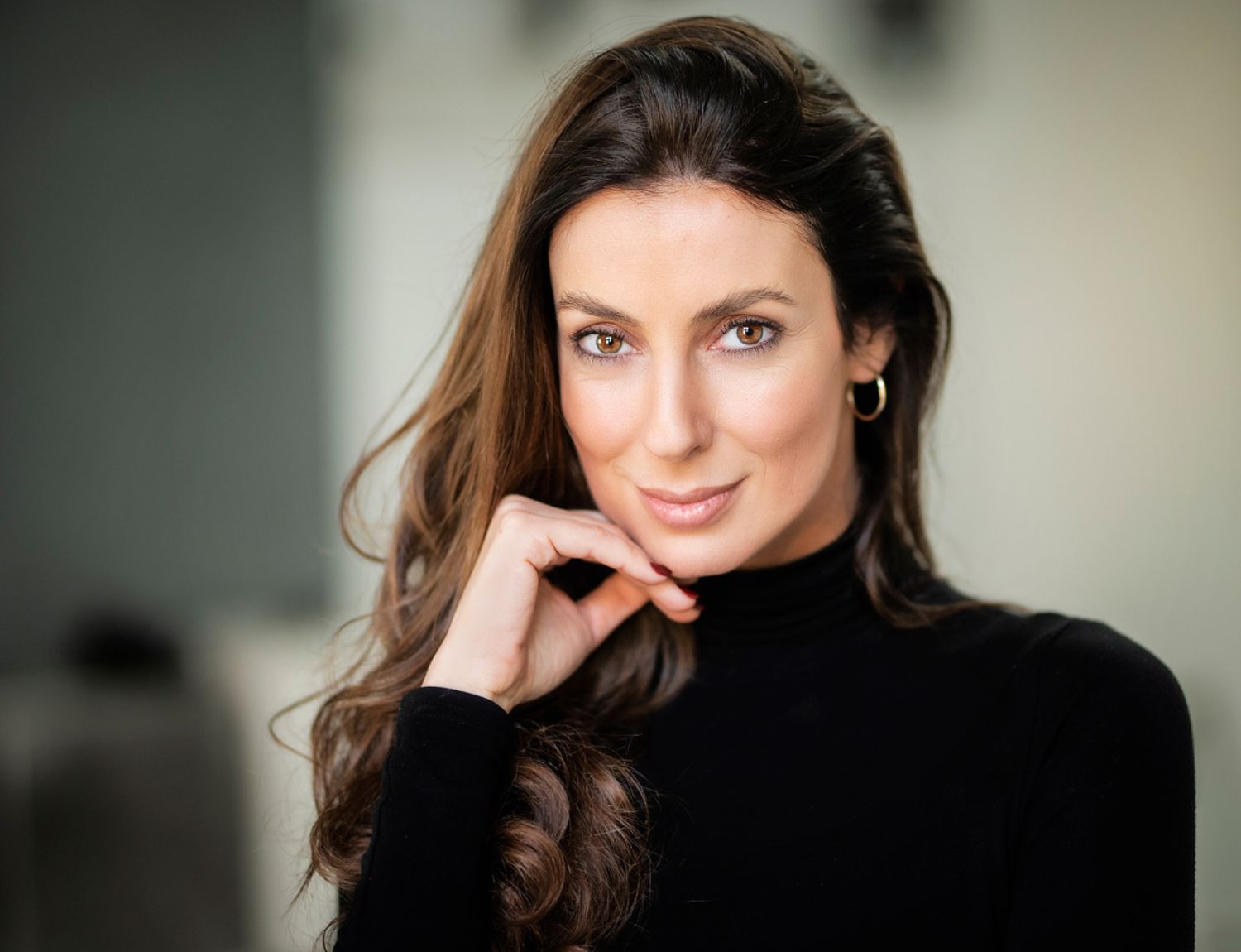 Smiling woman with long hair and clear skin.