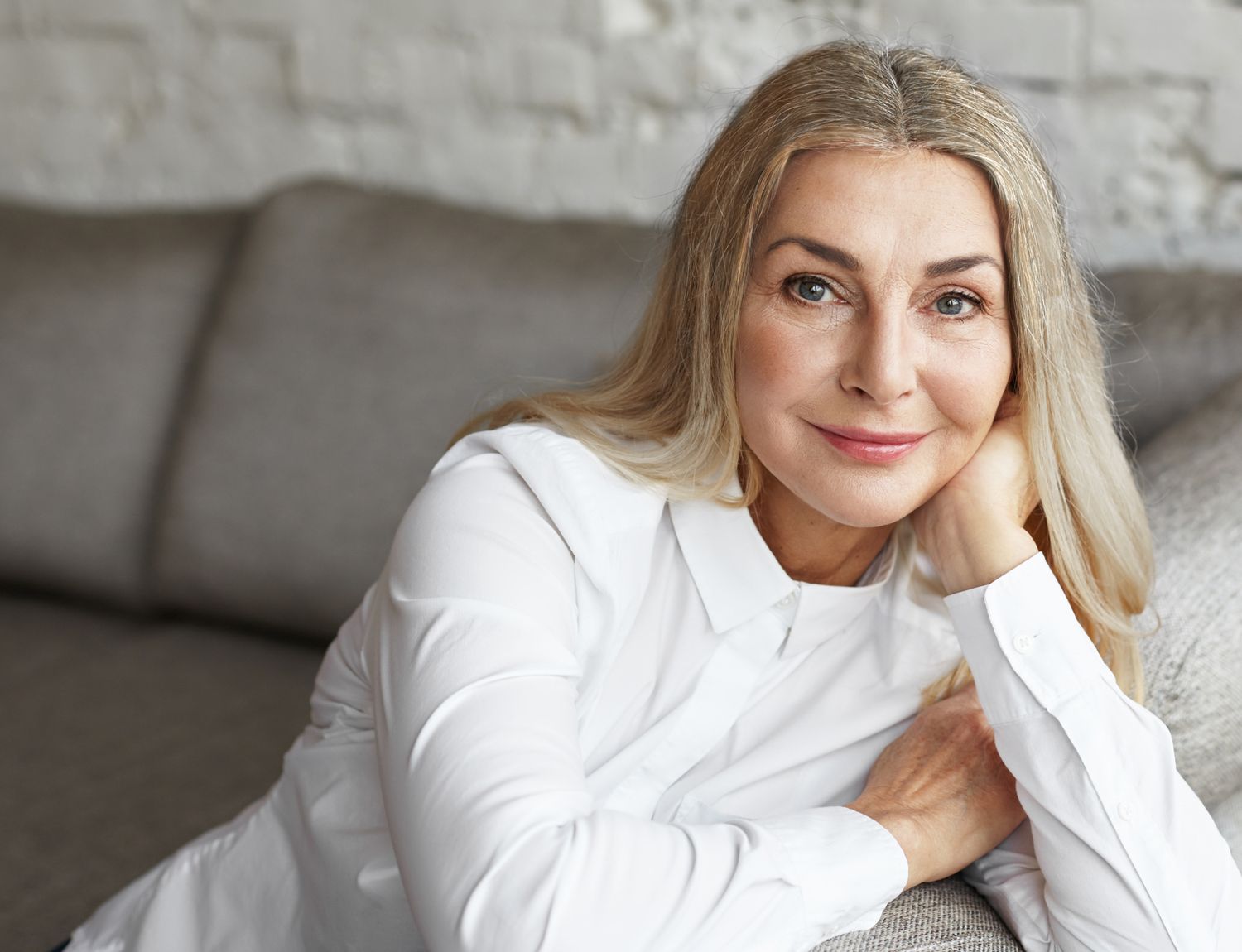 Smiling woman with long blonde hair indoors.