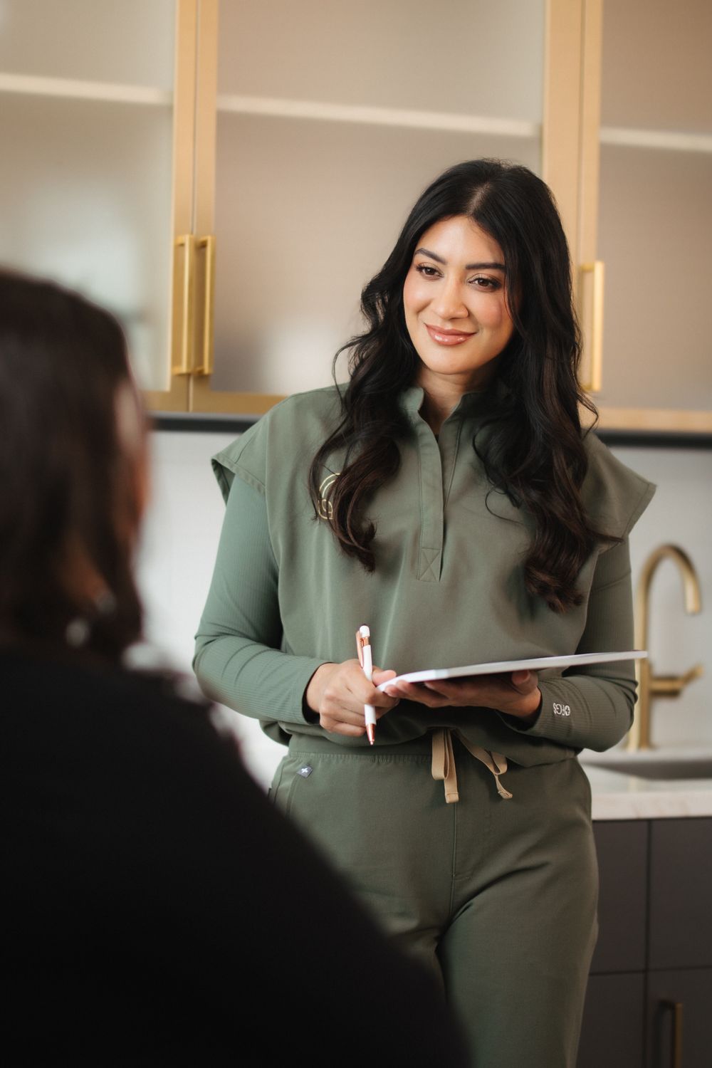 Smiling woman covering face with hand, joyful expression.