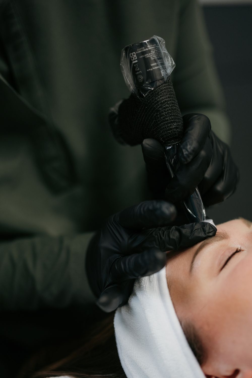 Beauty treatment with a tattoo machine in process.