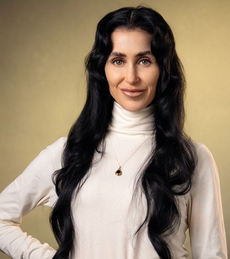 Woman with long black hair and turtleneck sweater