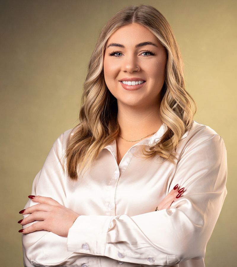 Smiling woman with long hair and stylish blouse.