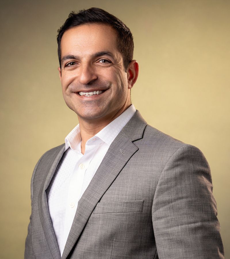 Smiling man in a gray suit portrait.