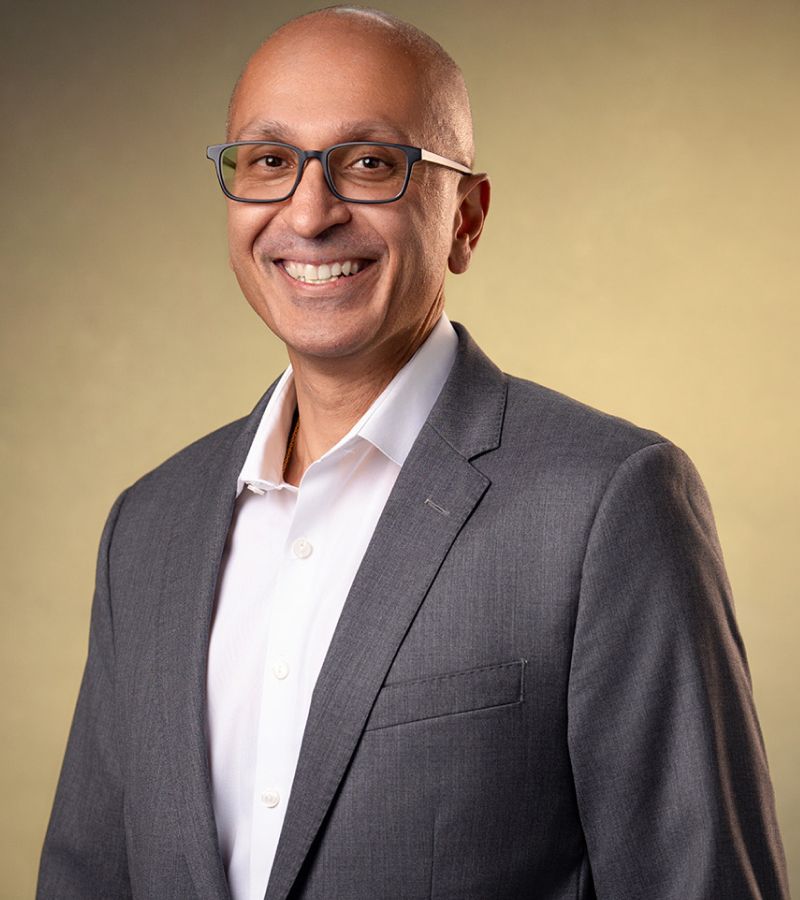Professional smiling man in grey suit portrait.
