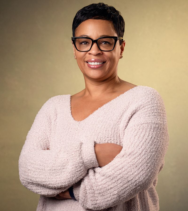 Smiling woman with short hair wearing glasses.
