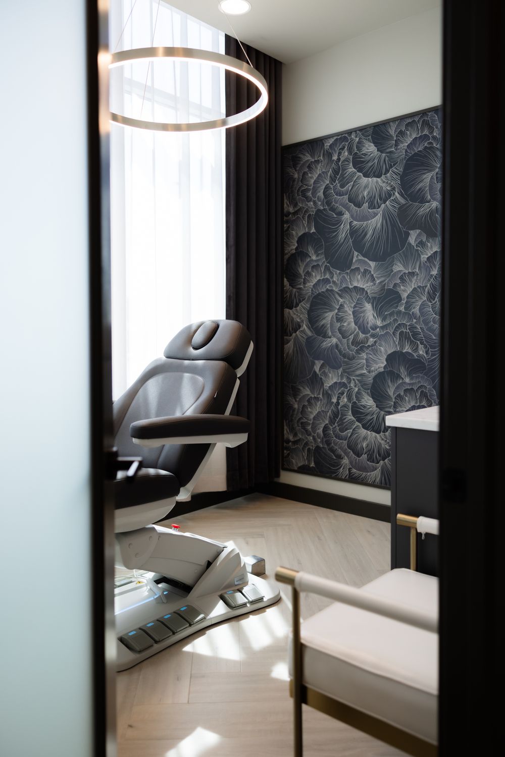 Modern treatment room with stylish decor and chair.