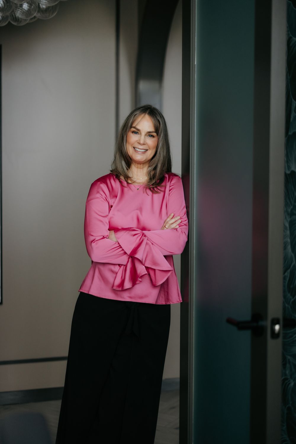 Woman in black athletic wear outdoors, sunlit pose.