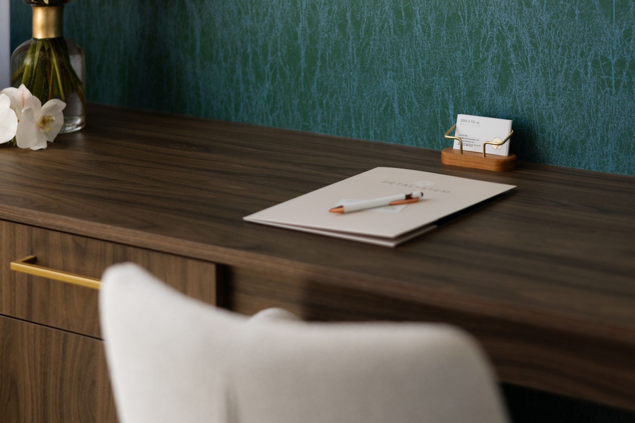 Elegant desk with stationery and floral accents.