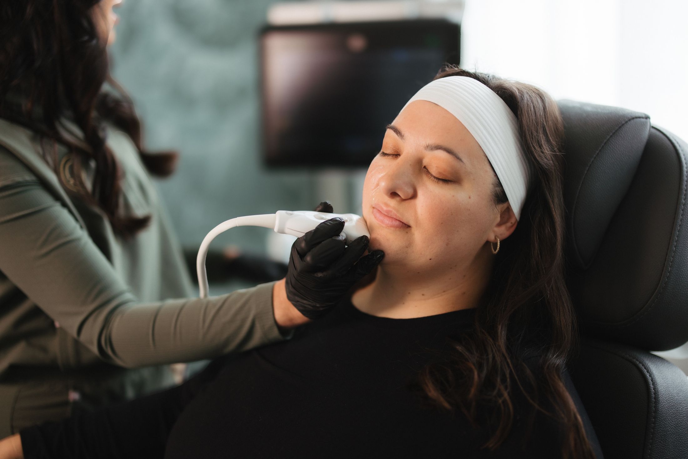 Woman receiving facial treatment in beauty salon.